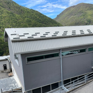 Graues Gebäude vor Bergpanorama. Im Fenster ist der Schriftzug C.A.M.P zu lesen.