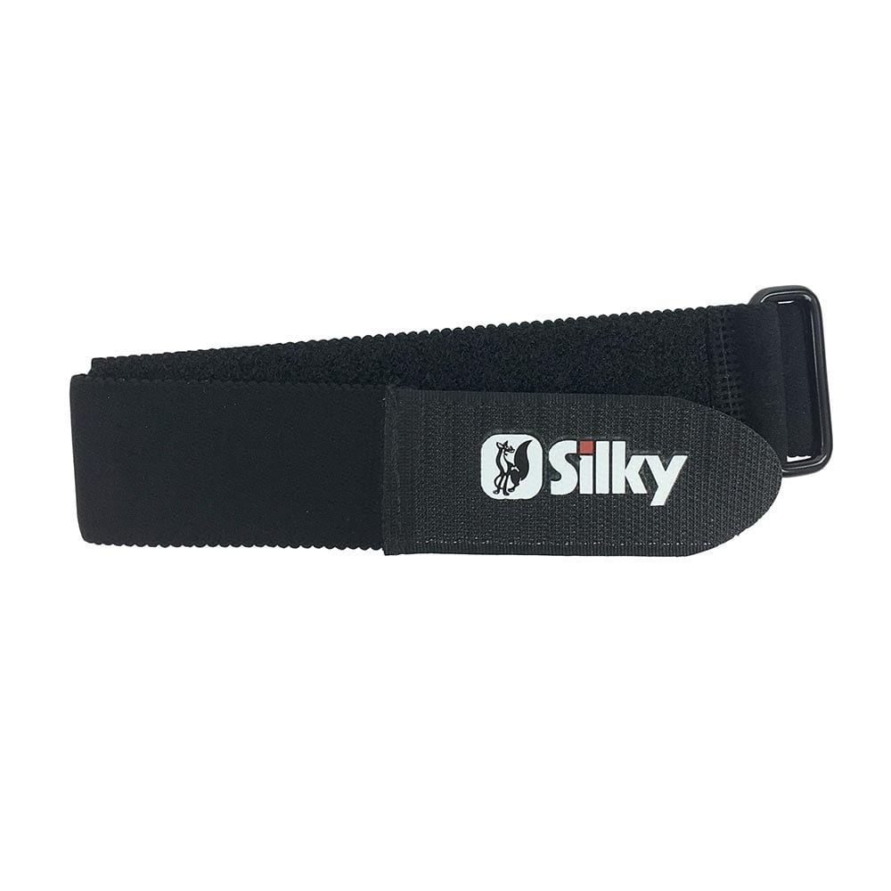 Silky Beinberiemung in Schwarz mit Silky-Logo auf einem rechteckigen Etikett aus Stoff, flach liegend mit Schnalle auf der rechten Seite