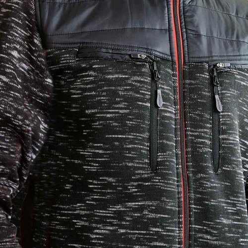 Nahaufnahme der schwarzen Inuit Winterjacke mit zwei senkrechten Brusttaschen mit Reißverschluss