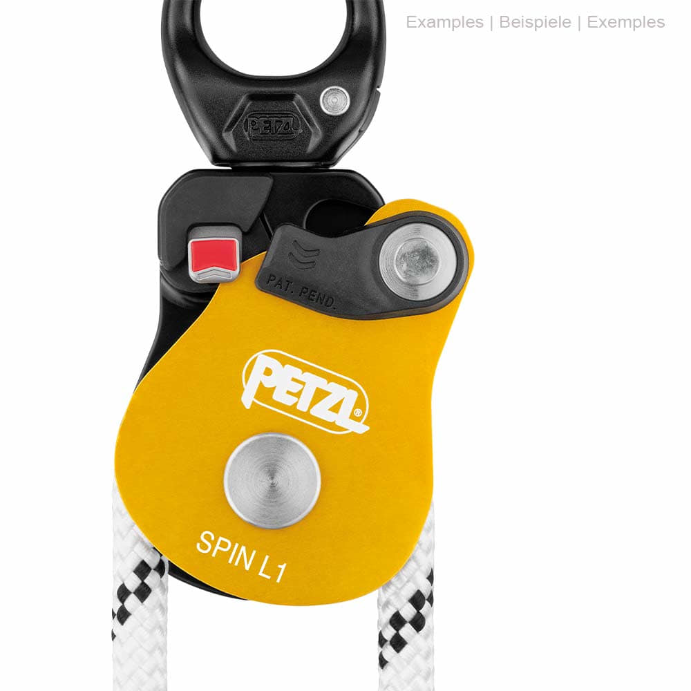 Nahaufnahme der Petzl Spin L1 Seilrolle mit gelbem Gehäuse, schwarzem oberen Teil und weißem Seil, rotem Knopf und Petzl-Logo