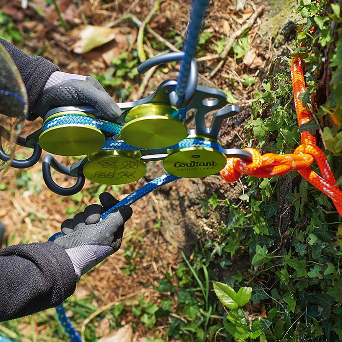 Hulk Produkt mit grünen runden Elementen und schwarzem Metallrahmen, verbunden mit blauen und orangen Seilen, wird von einer Person mit Handschuhen gehalten