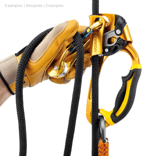 Rollclip A Karabinerhaken in orange an schwarzem Seil, gehalten von einer Hand mit gelbem Handschuh, verbunden mit einem gelb-schwarzen Klettergerät und einem orangen Karabinerhaken unten dran