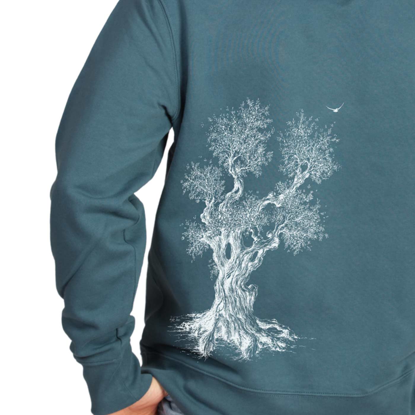 Olive Tree Hoodie in blaugrün, Detailansicht des weißen Baumdrucks auf dem Rücken, getragen von einer Person mit Hand in der Hosentasche