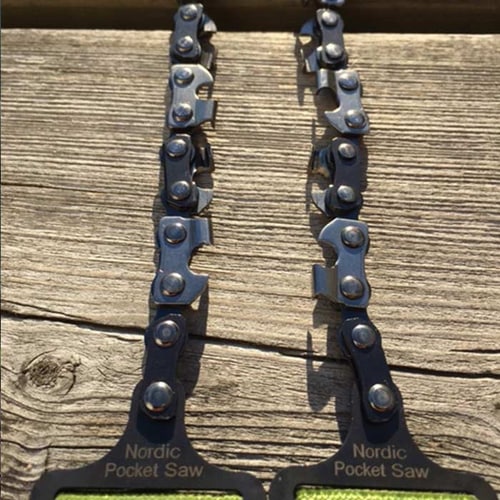 Nahaufnahme der Kette der Nordic Pocket Saw mit dem Schriftzug auf den schwarzen Griffen, auf Holz liegend