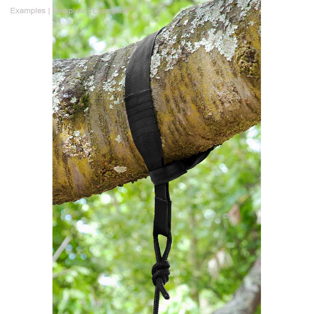 Schwarzer TreeMount Seat Gurt um einen Baumstamm gebunden mit Schnur und Knoten, im Hintergrund grüne Blätter sichtbar