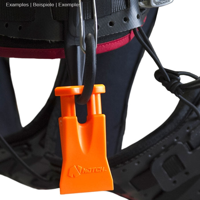 Climbers Best Friend Wedge von Notch, orangefarbener Kunststoffkeil mit zwei kurzen Stäben hängt an schwarzem Klettergurt mit roten Akzenten