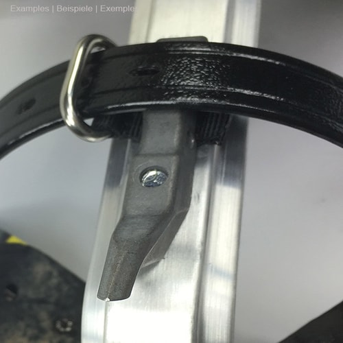 Distel Führungsöse für Lederberiemung an einem schwarzen Lederriemen befestigt, der um ein silbernes Metallteil gelegt ist, mit einer Schraube sichtbar im Metallteil befestigt