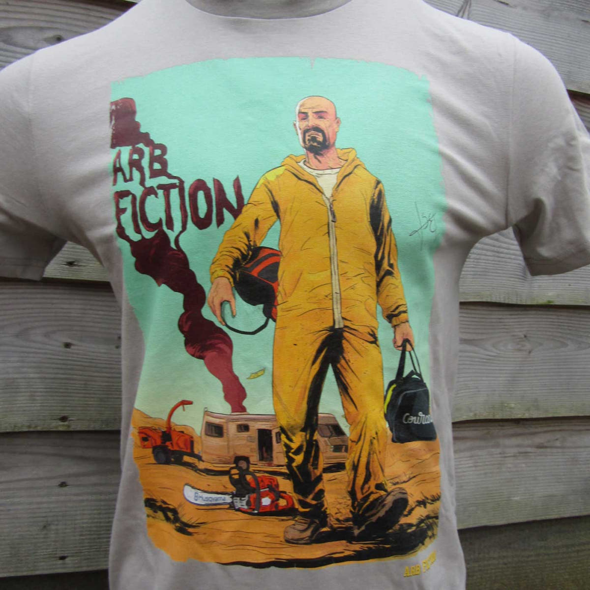 Breaking Bad T-Shirt beige mit Aufdruck eines Mannes in gelbem Schutzanzug, der einen Helm und eine Tasche hält, Herstellername nicht sichtbar