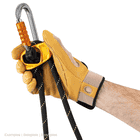 Hand mit gelbem Arbeitshandschuh hält das gelbe Metallgerät mit schwarzem Seil und einem silbernen Karabiner