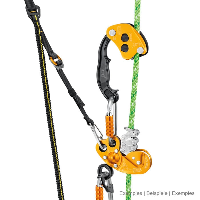 Petzl Chicane, gelb-schwarzes Sicherungsgerät mit Griff, verbunden mit einem Karabiner und einem schwarzen Band an einem grünen Seil