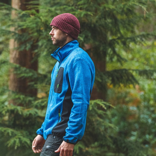 Mann trägt blaue Kudu Plus Fleecejacke mit schwarzer Brusttasche in einem Wald