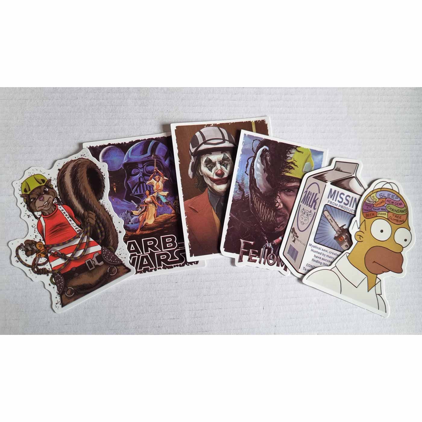 Mehrere bunte Aufkleber aus dem ARB Fiction Pack Vol. 4, darunter ein Eichhörnchen mit Helm, ein ARB WARS Poster, ein Joker mit rotem Anzug, eine Milchpackung mit Motorsäge, ein halber Venom mit Bauhelm und ein Homer Simpson Kopf mit Gedankenblasen