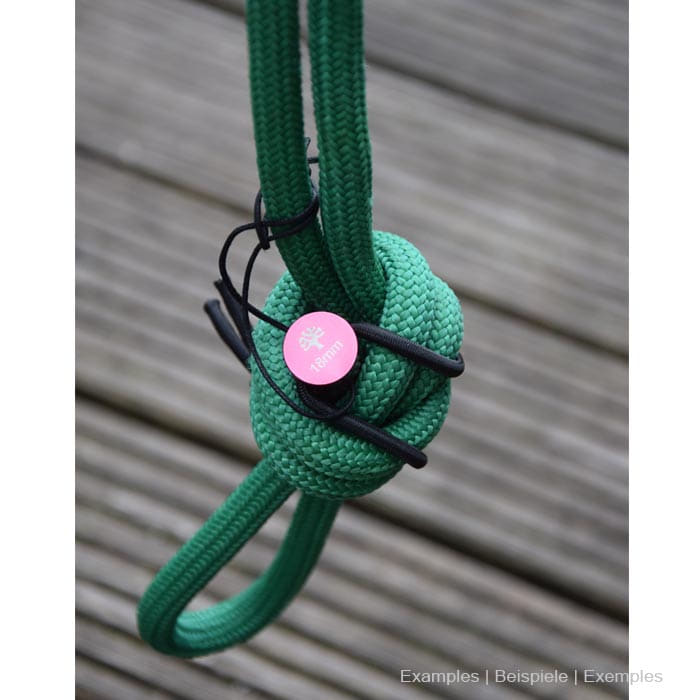 Rope Pin Set roter Pin an grünem Seil mit Knoten auf Holzuntergrund