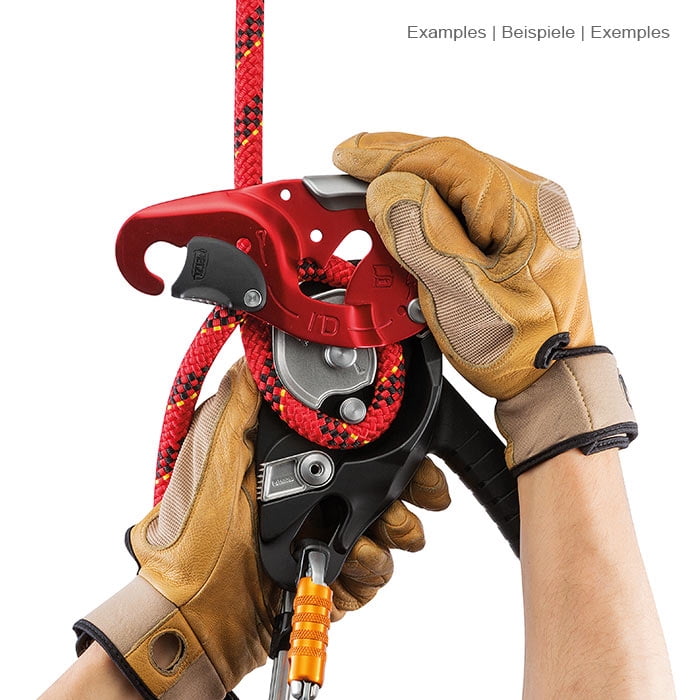 I'D L von Petzl, das Klettergerät wird von zwei Händen mit braunen Handschuhen gehalten, ein rotes Seil ist eingefädelt