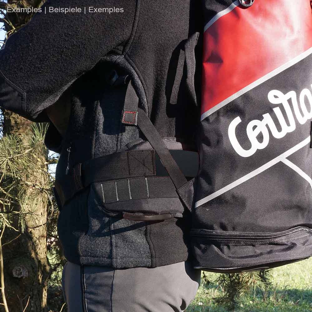 Person trägt schwarzen Cross Belt mit weißem Schriftzug "Courant" und rotem Rucksack, Hersteller nicht sichtbar