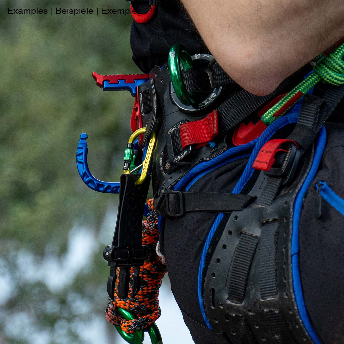 skyHOOK Open Gate in Blau und Rot an einem Klettergurt befestigt, im Einsatz bei einer Person mit Kletterausrüstung