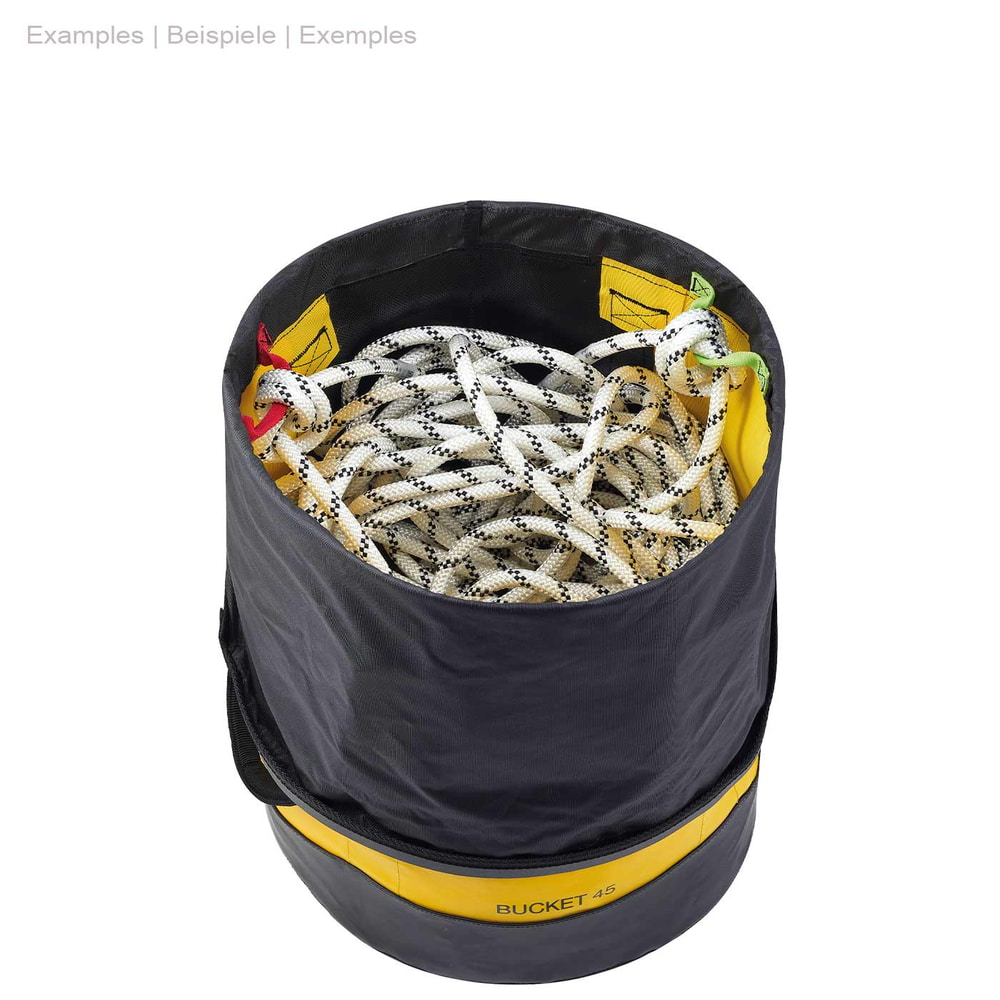 Runder gelber und schwarzer Petzl Bucket 45 mit offenem schwarzen Kordelverschluss oben, gefüllt mit einem weißen Kletterseil mit schwarzen Punkten