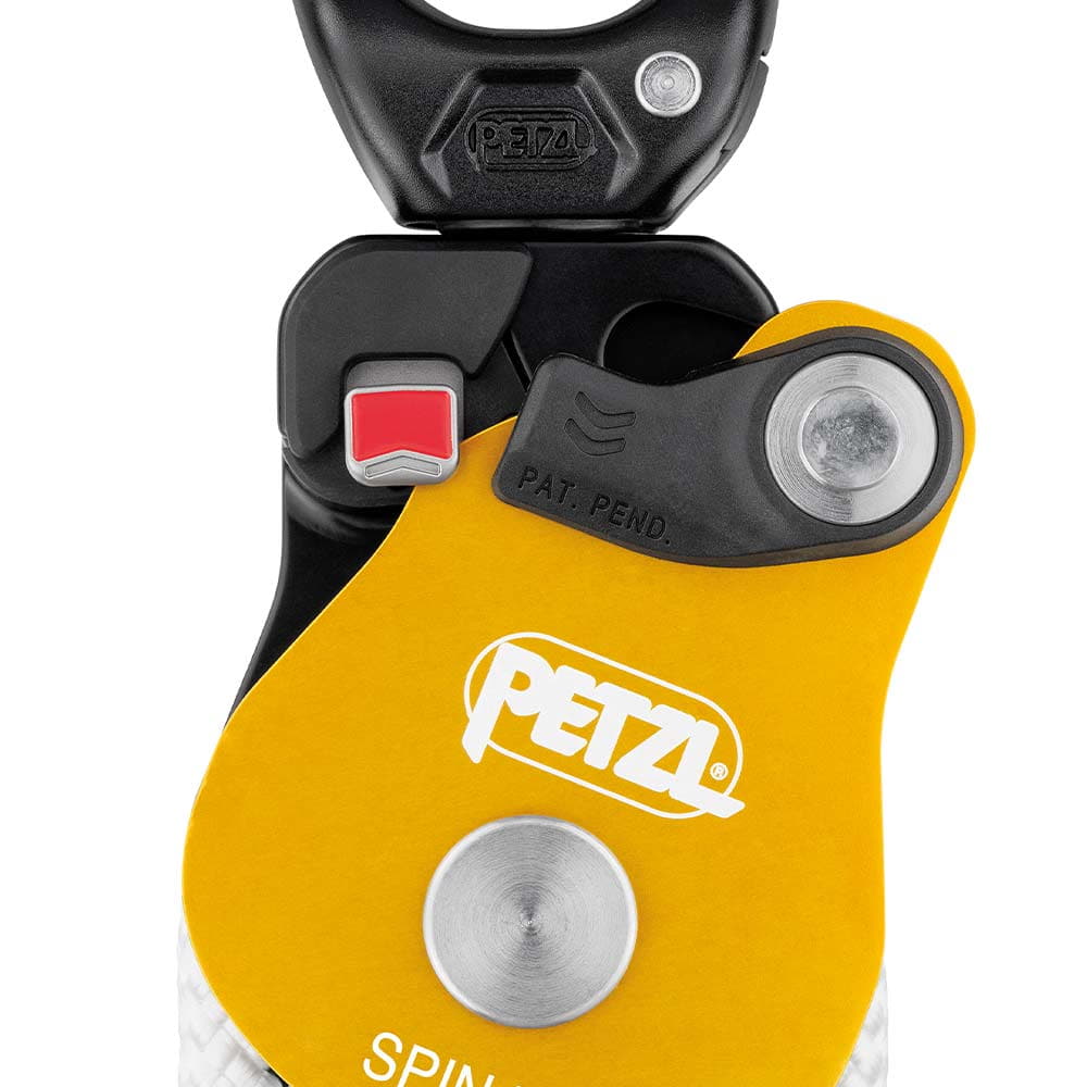 Nahaufnahme des Petzl Spin L2 Blocks mit gelbem Gehäuse, weißem PETZL-Logo, rotem Schalter und schwarzem Karabinerhaken