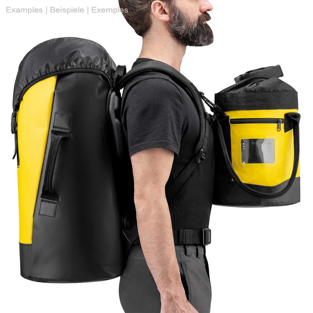 Mann trägt Petzl Transport 45 Rucksack in Gelb und Schwarz und hält einen kleineren gelb-schwarzen Beutel mit Reißverschluss