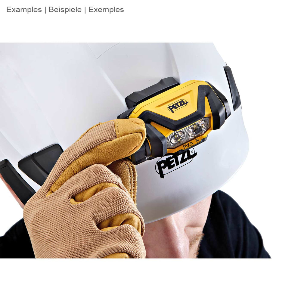 Petzl Pixa R Stirnlampe, montiert auf einem weißen Schutzhelm, eine Hand mit Arbeitshandschuh berührt die Lampe