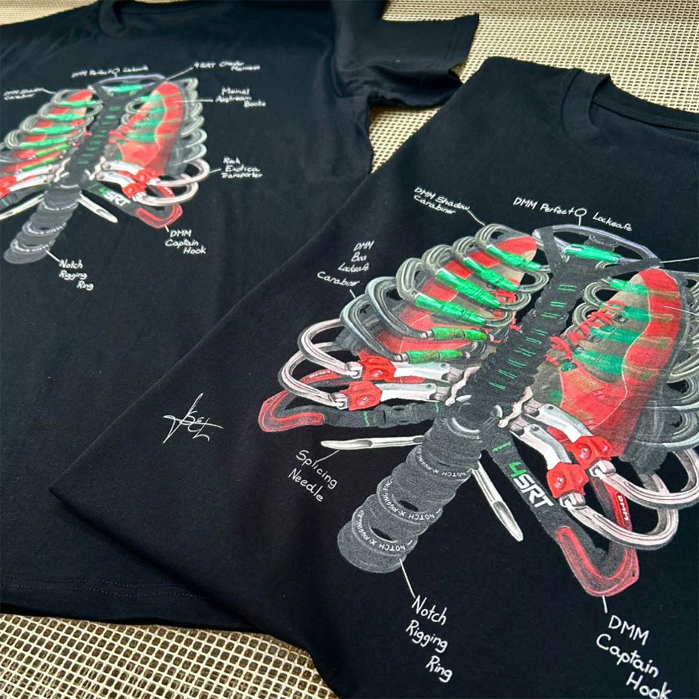Zwei schwarze Arb Ribs T-Shirts mit dem aufgedruckten Rippenkäfigmuster aus Kletterausrüstung liegen nebeneinander auf einer Oberfläche