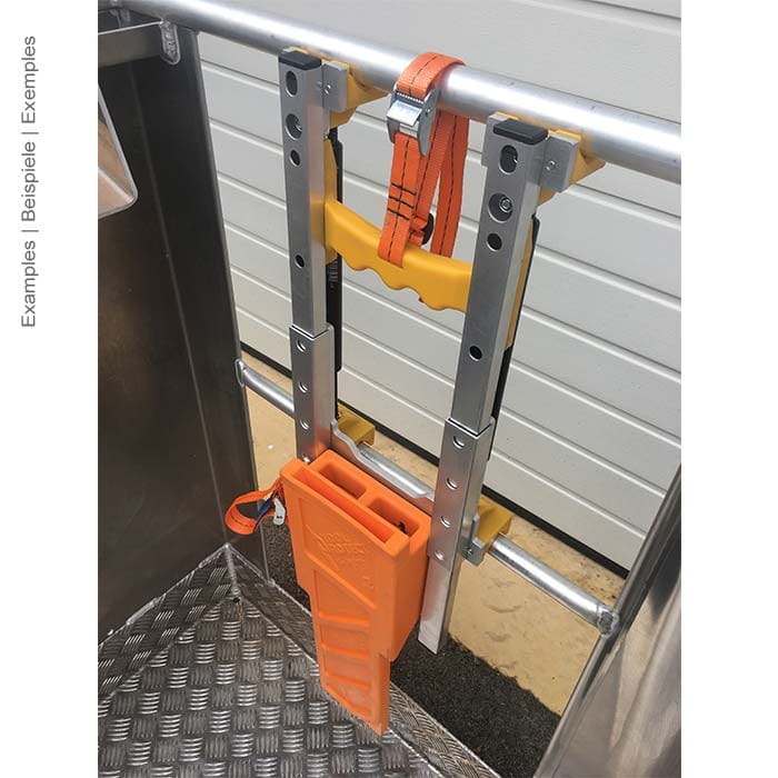 Anbauadapter Arbeitskorb Premium montiert an einem Metallgeländer mit orangefarbenem Gurt und einem orangefarbenen Werkzeughalter, Hersteller nicht sichtbar
