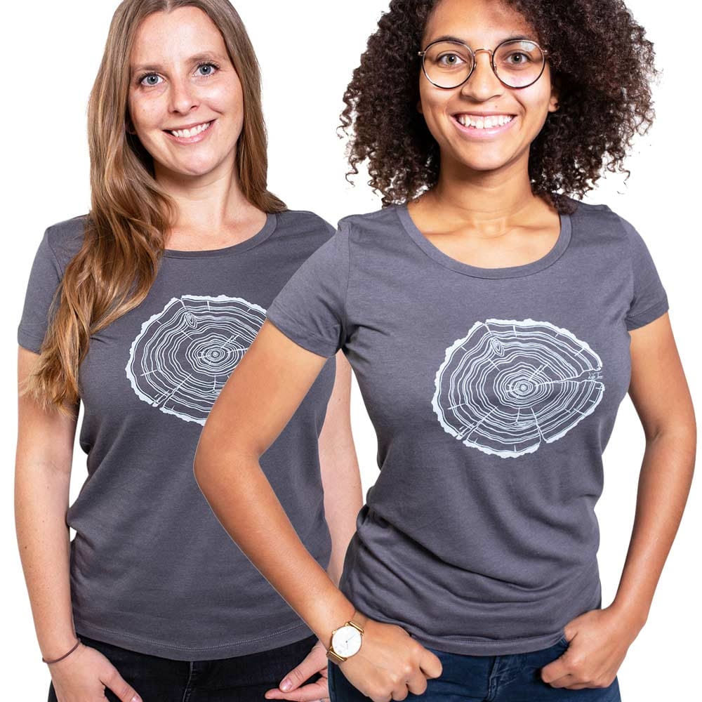Zwei Frauen tragen graue Treeslice Women T-Shirts mit weißem Baumstammschnitt-Design auf der Vorderseite, eine Frau hat lange blonde Haare, die andere trägt eine Brille und hat lockige dunkle Haare