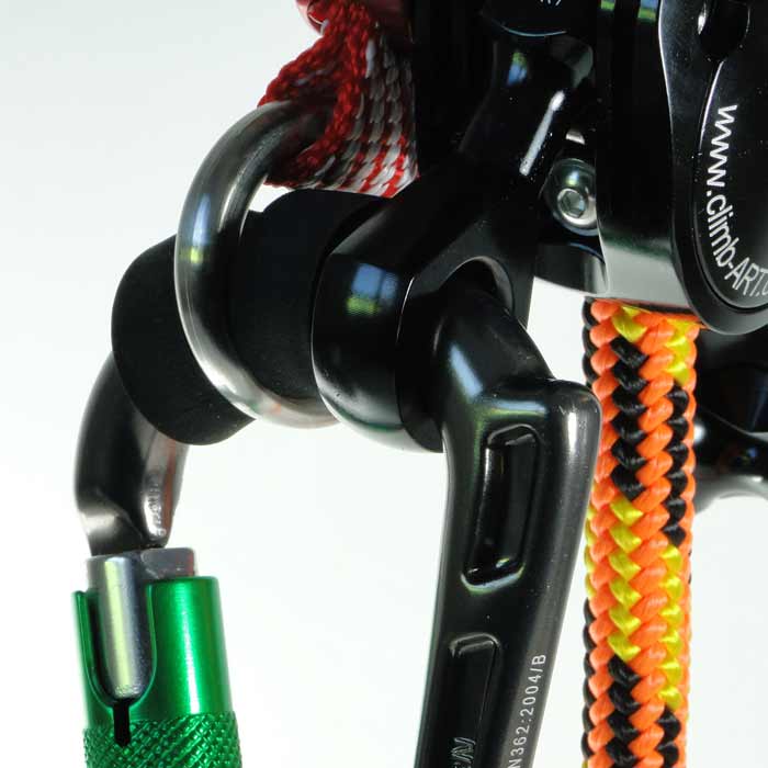Nahaufnahme eines schwarzen und grünen Rhino Karabiners, der an einem schwarzen Metallteil mit buntem Seil befestigt ist