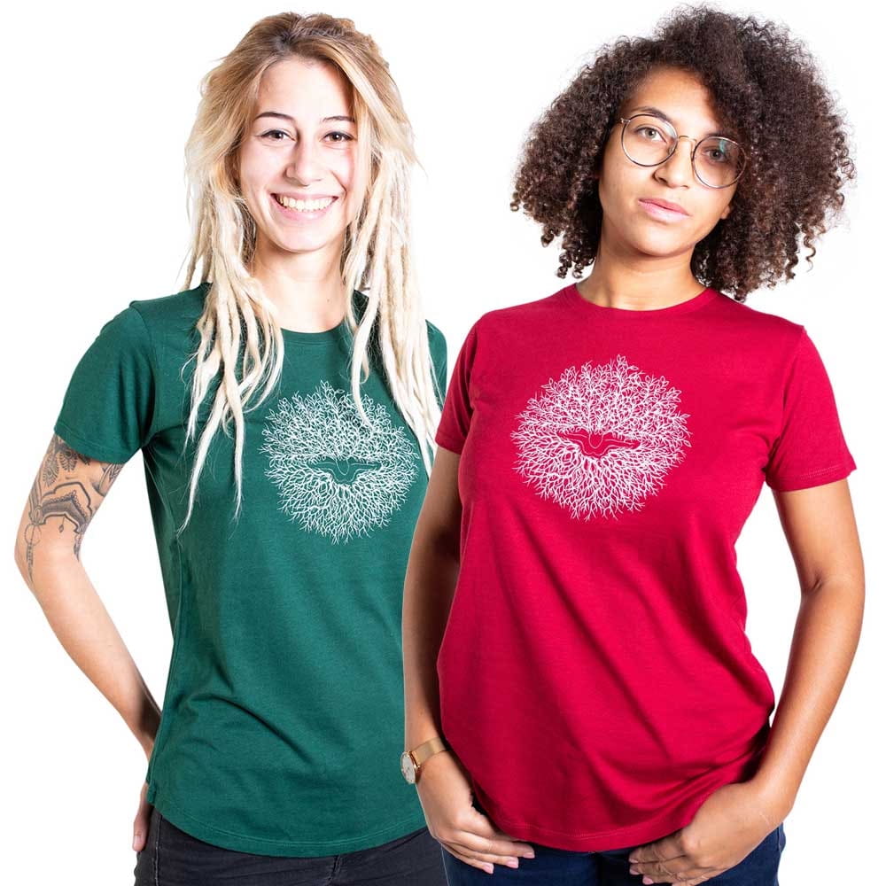 Zwei Frauen tragen T-Shirts mit dem Motiv "Ascension", eine in grün und eine in rot, beide T-Shirts zeigen ein weißes, kreisförmiges Muster mit einem Vogel in der Mitte.