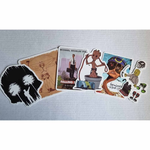 Sechs ARB Fiction Pack Vol. 3 Aufkleber liegen nebeneinander auf weißem Hintergrund, darunter ein schwarzer Aufkleber mit zwei weißen Bäumen, ein Aufkleber mit einem Mann in Anzug und Kettensäge mit der Aufschrift "Michael Douglas Fir Falling Down", ein t
