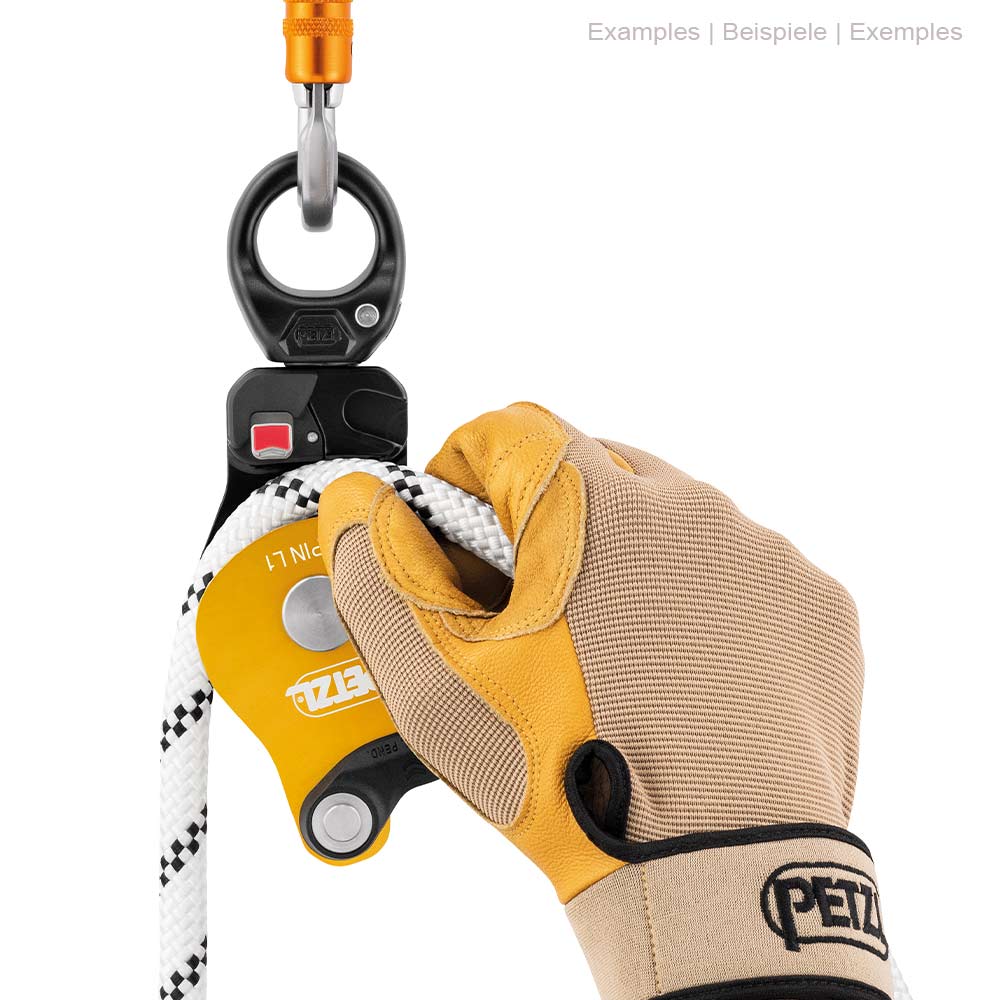 Petzl Spin L1 Seilrolle mit weißem Seil, gehalten von einer Hand mit Arbeitshandschuhen, an einem Karabiner befestigt