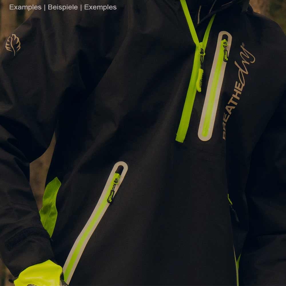 Nahaufnahme einer Person mit schwarzer BreatheDry Smock Jacke mit grünen Details und Reißverschlusstaschen