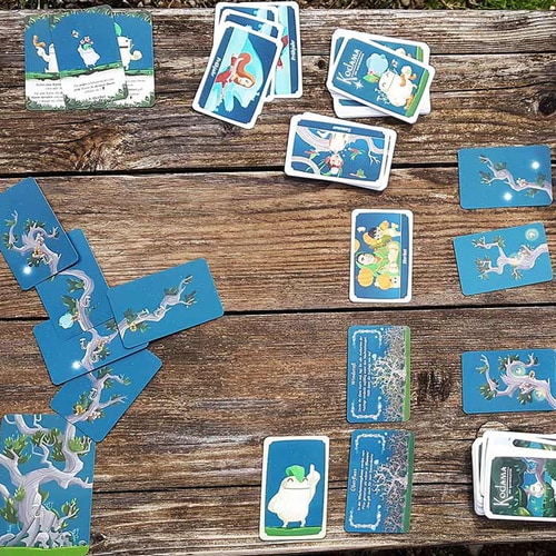 Kodama – Die Baumgeister Kartenspiel mit mehreren Karten auf Holztisch verteilt, Kosmos Herstellername nicht sichtbar