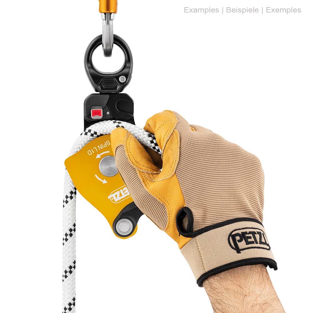 Petzl Spin L1D Seilrolle mit Handschuh an einer Hand, die ein weißes Seil hält