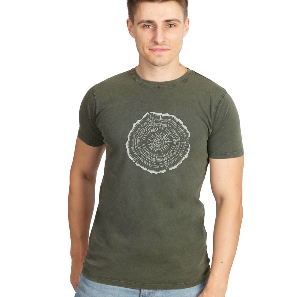 Mann trägt das olivgrüne Treeslice T-Shirt mit weißem Baumstamm-Querschnitt-Motiv, dazu blaue Jeans