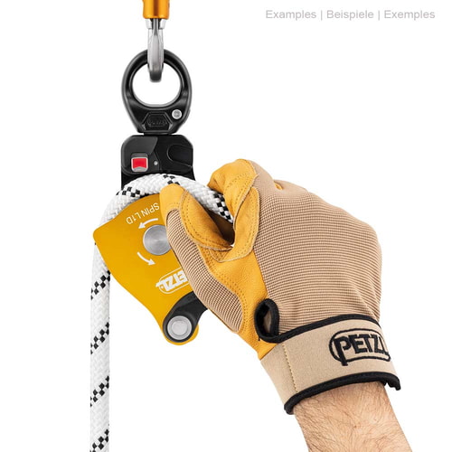 Petzl Spin L1D Seilrolle mit Handschuh an einer Hand, die ein weißes Seil hält