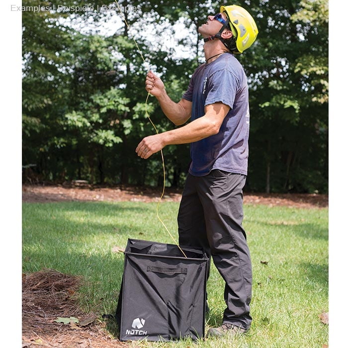 Mann mit gelbem Helm und Sonnenbrille steht auf Gras und hält orangenes Seil über einem schwarzen Pro Folding Cube von Notch
